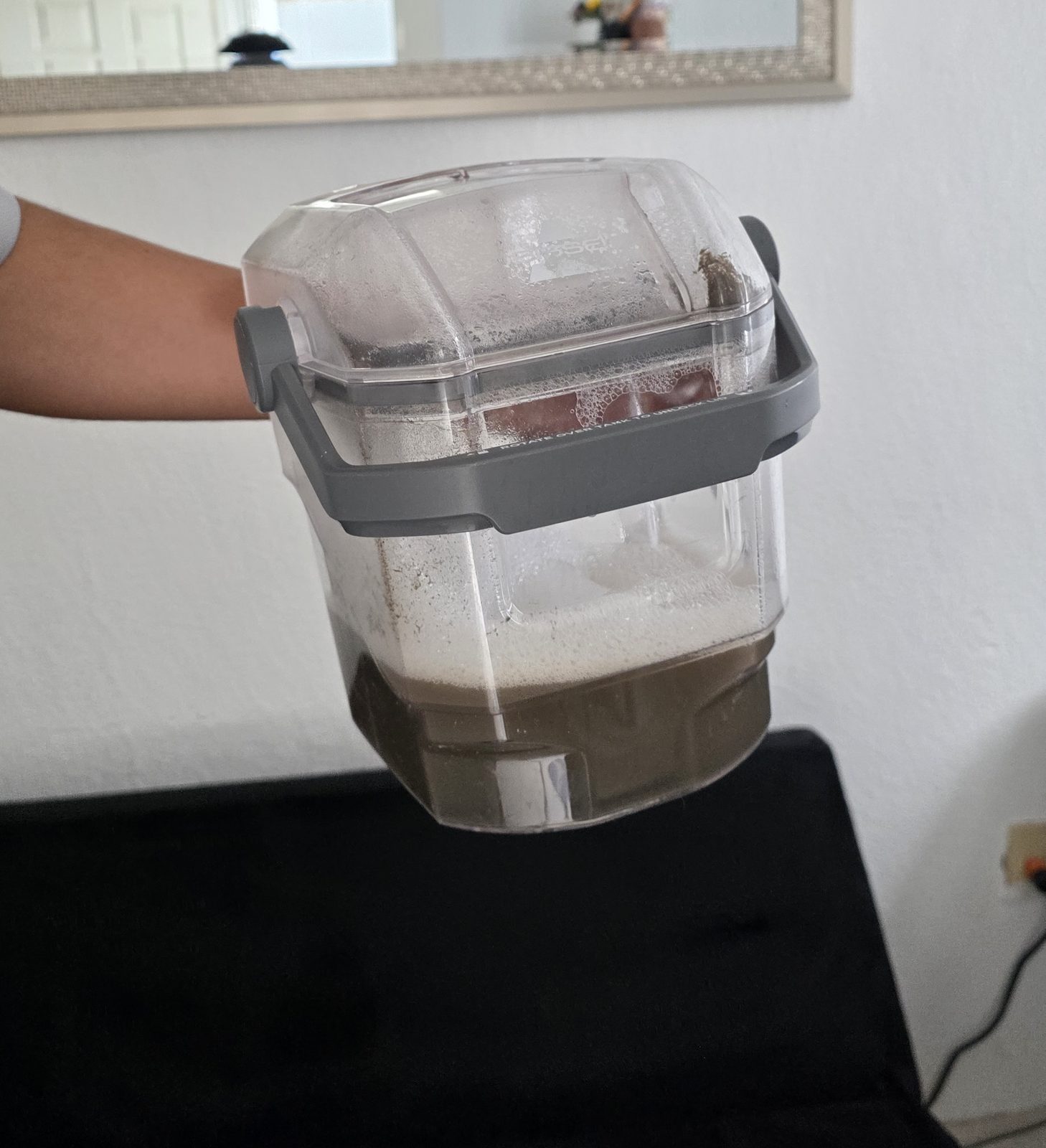 Agua con la suciedad extraída de la tapicería